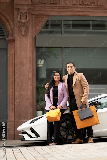 Portrait of father and adult standing by luxury car