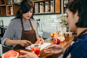 portrait of happy asian mother and daughter at home making some fresh dessert together in the kitchen