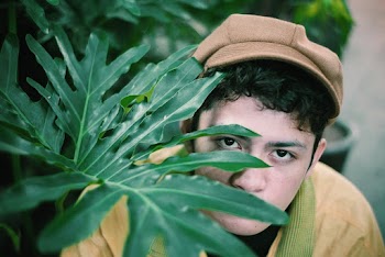 Portrait of Man Wearing Yellow Top Behind of Green Plant