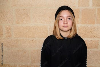 Portrait of serious Caucasian teenager girl brick stone wall background