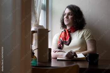 portrait of transgender woman sitting by window