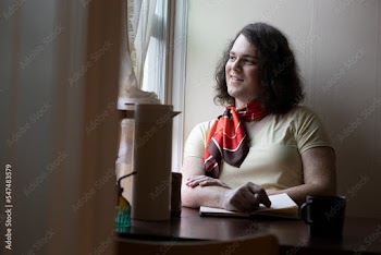 portrait of transgender woman sitting by window