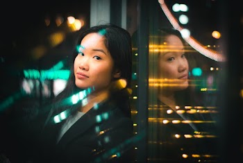 Portrait of Woman Leaning On Glass Wall