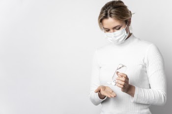 Portrait of woman sanitizing hands with gel Free Photo