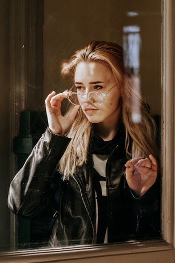 Portrait of Woman Wearing Black Leather Jacket in Front of Window