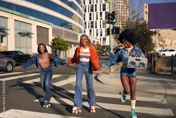 Portrait of young friend group rollerskating together in the city smiling 
