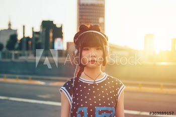 Portrait of young woman listening to music on street