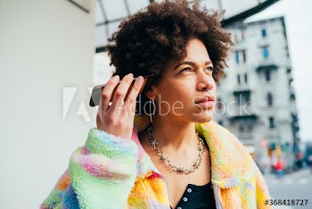 Portrait of young woman listening voice message on smartphone