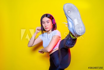 Portrait of young woman practicing kickboxing indoors