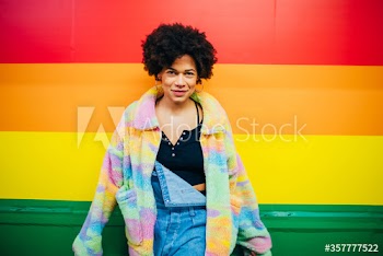 Portrait of young woman standing by wall