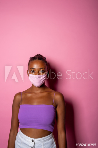 Portrait of young woman wearing face mask standing indoors