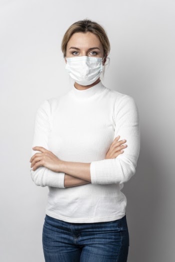 Portrait of young woman with surgical mask posing Free Photo