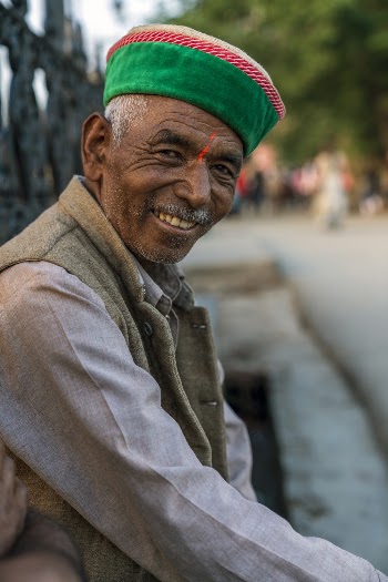 Portrait photo of a cheerful elderly man sitting down