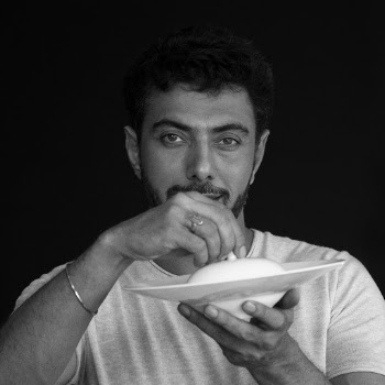 Portrait Photo of a Man in White T-Shirt Holding White Plate and Lid on Black Background