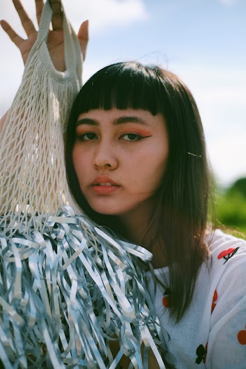 Portrait photo of a woman holding a grey and beige net