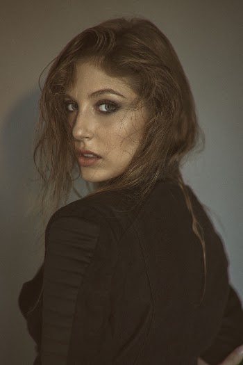 Portrait photo of a woman in black shirt with her back against the camera