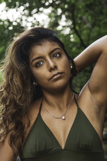 Portrait photo of a woman wearing a green sleeveless top