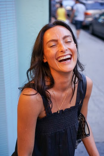 Portrait Photo of Laughing Woman with Her Eyes Closed in Black Top