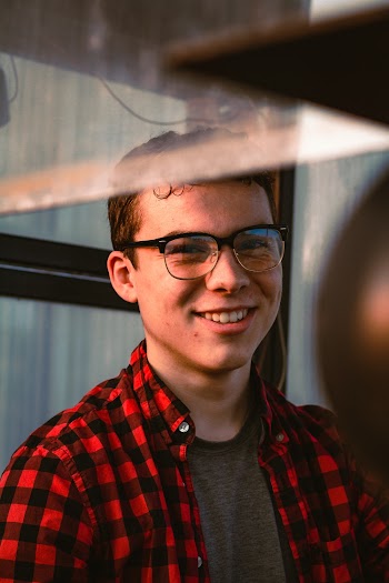 Portrait Photo of Man in Glasses and Red and Black Plaid Shirt Smiling