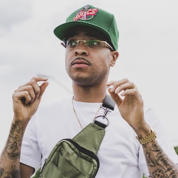 Portrait Photo of Man in Green Cap, White T-shirt, and Cross-body Bag