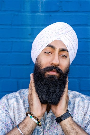 Portrait Photo of Man Wearing Floral Button-up Shirt and Turban Holding His Beard