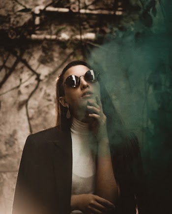 Portrait Photo of Posing Woman in Black Sunglasses and Black Coat