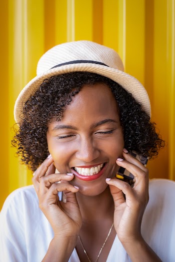 Portrait Photo of Smiling Woman in Hat Posing With Her Eyes Closed