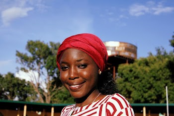Portrait Photo of Smiling Woman in Maroon Headscarf