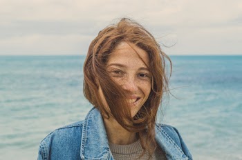 Portrait Photo of Smiling Woman with brown Hair Near Body of Water 