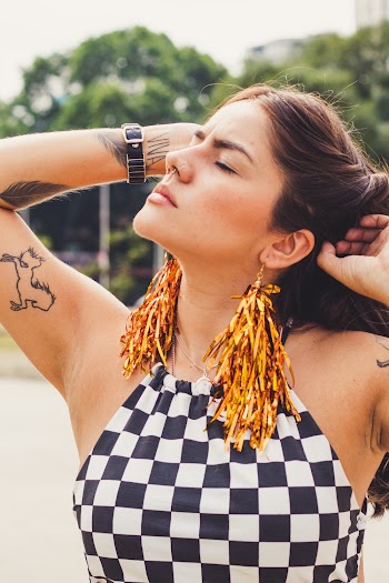 Portrait Photo of Tattooed Woman in Black and White Checkered Top Posing With Her Eyes Closed