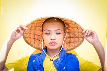 Portrait Photo of Woman in Bamboo Hat Posing With Her Eyes Closed