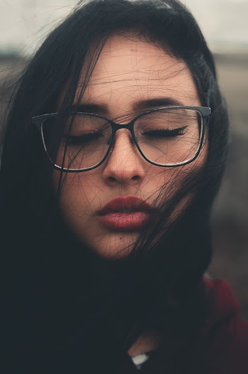 Portrait Photo of Woman in Black Framed Eyeglasses With Her Eyes Closed