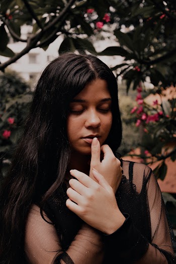 Portrait Photo of Woman in Black Long-sleeved Chiffon Top Under Green Leaf Tree With Her Eyes Closed