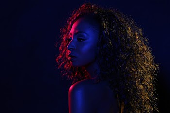 Portrait Photo of Woman in Blue and Red Light Background Posing