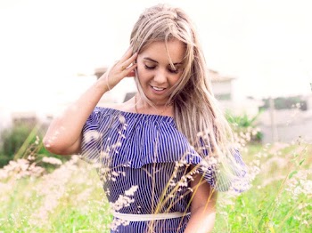 Portrait Photo of Woman in Blue and White Striped Outfit Posing While Looking Down
