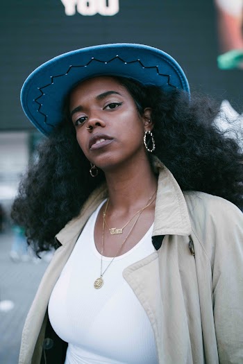 Portrait Photo of Woman in Blue Hat, Beige Coat, and  White Top Posing