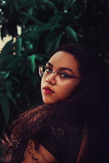 Portrait Photo of Woman in Glasses and Black Top Looking Behind