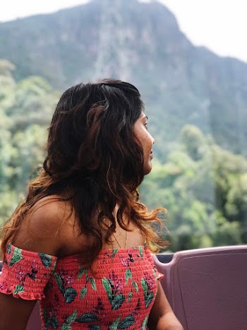 Portrait Photo of Woman in Orange Floral Off-shoulder Dress Looking Away