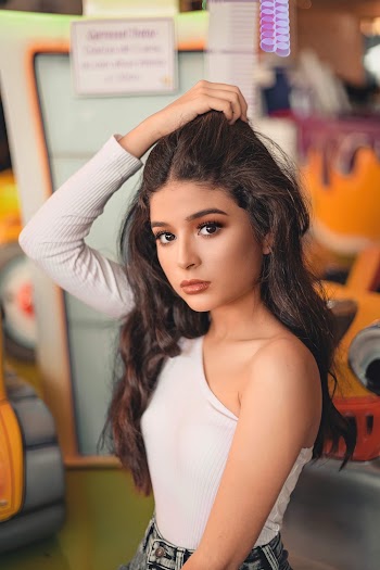 Portrait Photo of Woman in White One-sleeve Top Posing