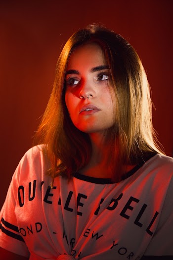 Portrait Photo of Woman in White T-shirt Posing While Looking Away