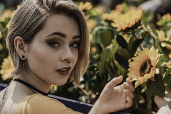 Portrait Photo of Woman Posing by Sunflowers