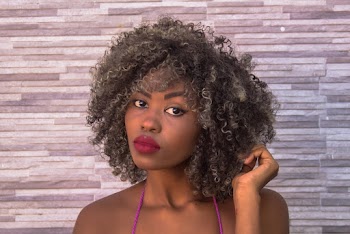 Portrait Photo of Woman Posing In Front of Gray Concrete Wall