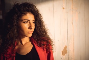 Portrait Photo of Woman Standing In Front of Wooden Wall Looking Away