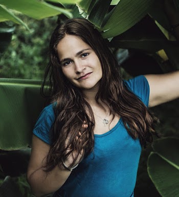 Portrait Photo of Woman Standing Next to Banana Leaves