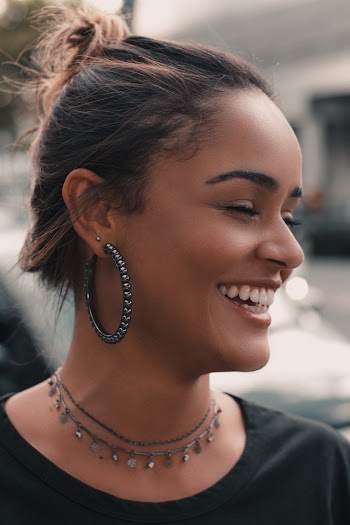Portrait Photo of Woman Wearing hoop earrings a Chocker Laughiing