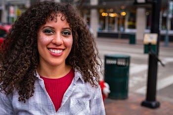 Portrait Photo of Woman With Face Glitter Smiling Beside Street