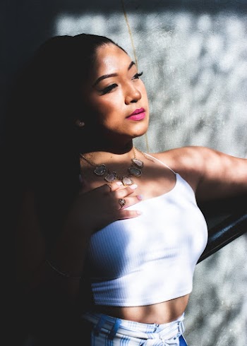 Portrait photo of women wearing a white spaghetti strap crop top