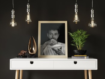 Portrait Photo on Wooden Frame  of Man Holding a White Plate and Lid Placed on a White Desk