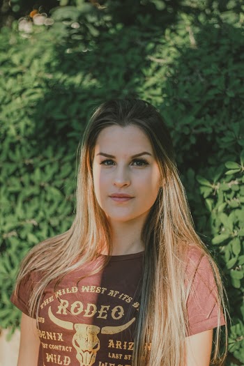 Portrait Photo Woman in Brown T-shirt Standing In Front of Green-leafed Plants