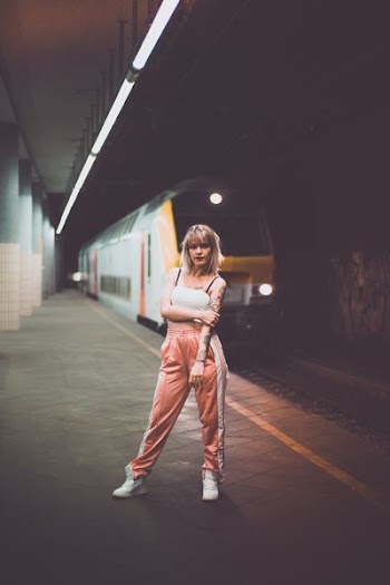portrait photography of woman standing near train